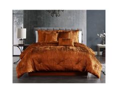 a bed with orange comforter and pillows in a room