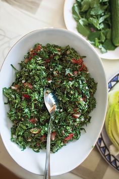 a white bowl filled with green vegetables and a fork