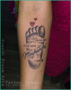 a tattoo on the leg of a person with a baby's foot and name