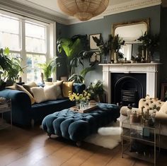 a living room filled with lots of furniture and plants on the wall above it's fireplace