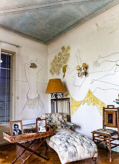 a living room filled with furniture and paintings on the wall