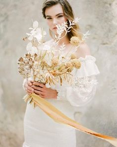 a woman holding a bouquet of flowers in her hands