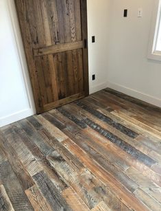 an empty room with wood flooring and a door in the corner that leads to another room