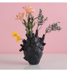 a heart shaped vase with flowers in it