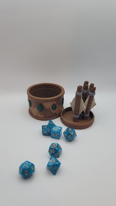 a set of blue dice sitting on top of a table next to a wooden container