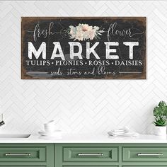 a kitchen with green cabinets and a sign that says market tulips - ponies, roses - daisies