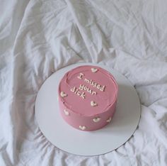 a pink cake on a white plate with the words i missed you later written on it