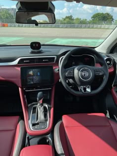 the interior of a car with red leather seats and steering wheel, dash board and dashboard