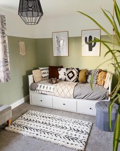 a living room filled with furniture and pictures on the wall next to a plant in a vase