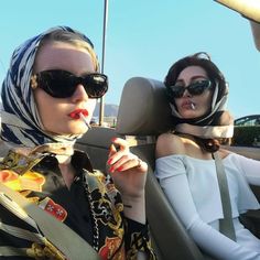 two women sitting in the back seat of a car