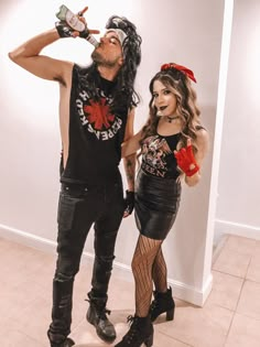 a man and woman dressed up in costume drinking from bottles while standing next to each other