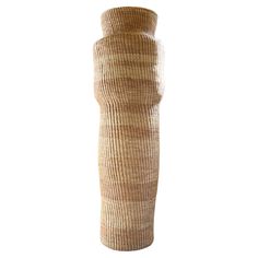 a tall vase is made out of straw and has a long tube in the middle