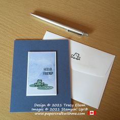 a greeting card and pen sitting next to each other on a wooden table with paper