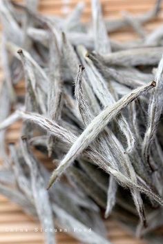 dried white flowers sitting on top of a wooden table