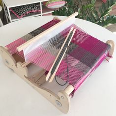 a weaving machine sitting on top of a white table