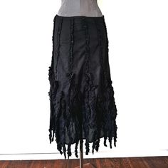 This vintage 90s/y2k skirt is export deadstock and was sourced in New Delhi. The black cotton midi skirt has an invisible side zipper and hook and eye closure.  The front and back are lined with seams of black lace that have sequins on them at intervals. About halfway down the skirt, there are lines of  raw edged cotton ruffles going down the skirt and hanging past the hem to form a sort of fringe. Note that the waist has no elastic, and the fabric has no stretch. Can see this styled with a corset and Doc Martens!  Measurements and details: -Total Length: 32 in (Skirt hem is at 29 in, while the fringe extends out to 32 in)  -Waist: 30 in -Hips: 48 in  Label: Dimri Material: 100% cotton  Condition: Very Good Flaws: some sequins are bent, and there is a small rip on the lace of one of the se Black Cotton Ruffled Skirt, Cotton Skirt For Alternative Fashion In Spring, Spring Cotton Skirt For Alternative Fashion, Lace Ruffle Skirt, Ripped Skirt, Thrift Manifestation, Black Floral Skirt, Outfit References, Y2k Skirt