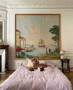 a bedroom with a large painting on the wall and stuffed animals laying on the bed