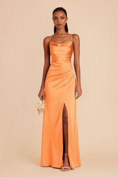 a woman wearing an orange dress with a slit in the side