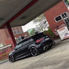 a black car is parked in front of a gas station