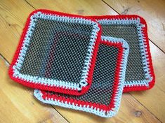 two crocheted placemats sitting on top of a wooden floor next to each other