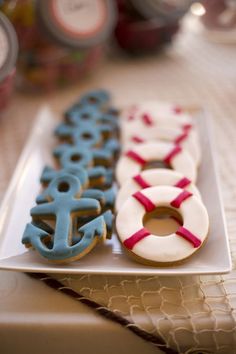 decorated donuts are on a plate with red, white and blue icing in the shape of an anchor