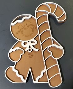 a cookie shaped like a ginger holding a candy cane