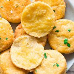 small crackers with green sprinkles are on a white plate, ready to be eaten