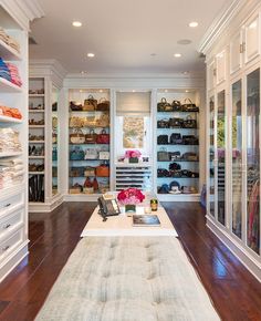 a large walk in closet with lots of shoes and handbags on the shelfs