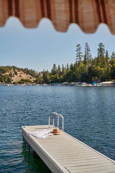 a boat dock with a chair on it in the middle of a body of water