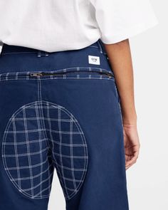 the back view of a person wearing blue pants with white checkered pattern on them