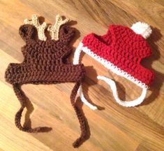 two crocheted reindeer hats laying on top of a wooden floor