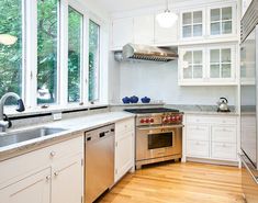 an image of a kitchen setting with white cabinets and stainless steel stove top ovens