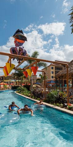 people are swimming in the pool with floats and toys hanging from the rafts over them