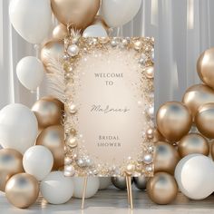 a welcome sign surrounded by balloons and streamers in gold, white and silver colors