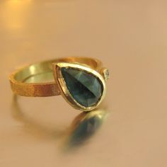 a gold ring with a green stone on it