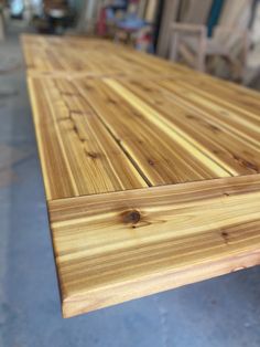 a close up of a wooden table in a room with other woodworking supplies behind it