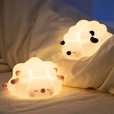 two sheep shaped lamps sitting on top of a bed