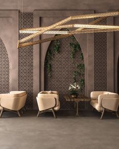 an elegant dining room with beige chairs and gold accents on the walls, along with greenery