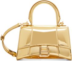 Structured patent calfskin top handle bag in metallic gold tone. · Rolled carry handle · Adjustable and detachable crossbody strap · Patch pocket at back face · Curved base · Logo hardware at foldover flap · Nappa lambskin lining · Logo-engraved gold-tone hardware · H4.5 x W7.25 x D2.5 Supplier color: Gold Gold Balenciaga Bag, Balenciaga Hourglass Bag, Balenciaga Tote Bag, Balenciaga Purse, Balenciaga Tote, Gold Bodies, Girly Bags, Balenciaga Bag, Handle Bag