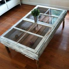 an old window coffee table with potted plant on top