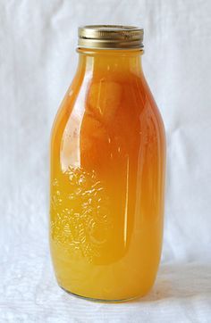 a glass jar filled with liquid sitting on top of a white cloth covered tablecloth