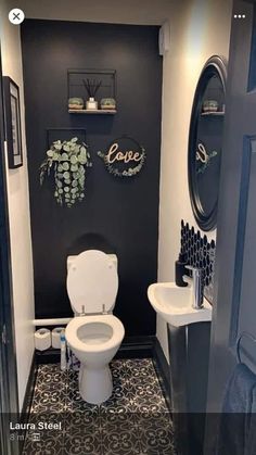 a white toilet sitting inside of a bathroom next to a sink and mirror on the wall