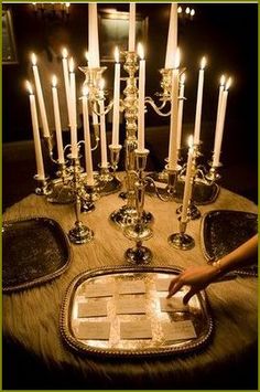 there is a tray with many lit candles on it and one person touching the plate