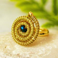 Laura Villalvazo in Mexico creates intriguing jewelry using pine needles gathered from the forest floors of Jalisco. In this unique cocktail ring the pine needles are woven into a tight spiral that is centered by an iridescent teal crystal bead. The spiral is set on a slender 14k gold plated copper band. Mexico Gift, Unique Cocktails, Leaf Ring, Pine Needles, In The Forest, Jewelry Packaging, Cocktail Ring, Jewelry Gift Box, Cocktail Rings