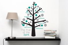 a shelf with a lamp and a wall decal that says the fruit of the spirit