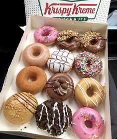 an open krispy kreme box filled with assorted donuts