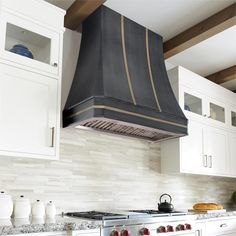 a stove top oven sitting inside of a kitchen next to white cabinets and counter tops