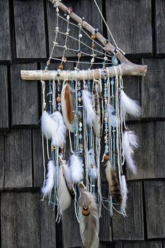 a dream catcher with feathers hanging from it's side