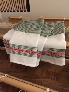 two white towels sitting on top of a wooden table