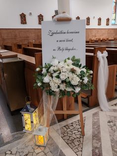 a bouquet of flowers sitting on top of a wooden stand in front of pews